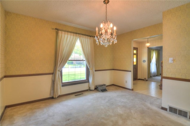 2290 N Kenwood Ct, Decatur, IL 62526 - spare room with a chandelier, carpet, a textured ceiling, and baseboards