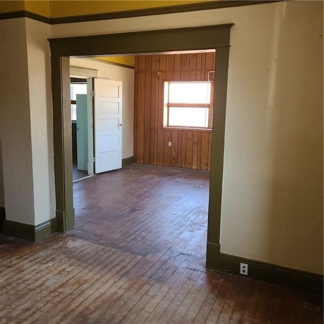 unfurnished room with baseboards and wood-type flooring