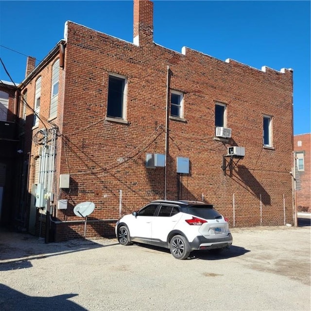 exterior space with brick siding and a chimney