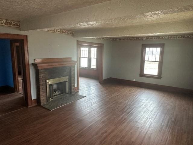 unfurnished living room with wood finished floors, a fireplace, and a wealth of natural light