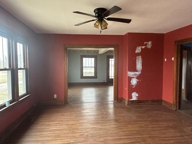 unfurnished room featuring ceiling fan, baseboards, and wood finished floors