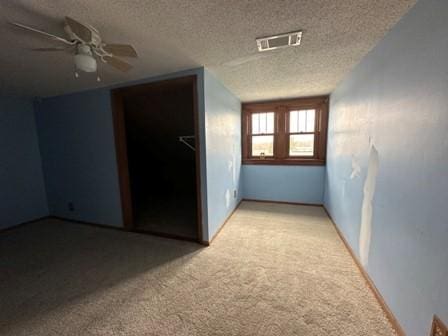 interior space with visible vents, carpet, and a textured ceiling