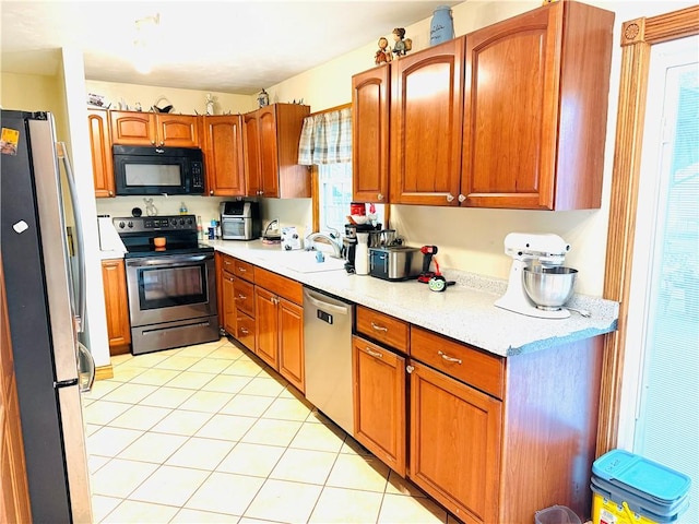 211 E 5th Ave, Rankin, IL 60960 - kitchen featuring appliances with stainless steel finishes, a sink, light tile patterned floors, and brown cabinetry