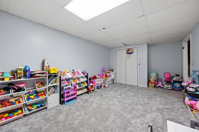 playroom with carpet and a paneled ceiling
