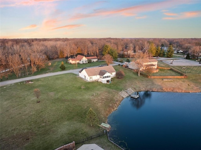 aerial view at dusk featuring a water view