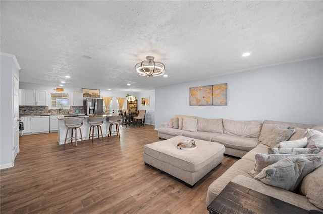 living room with a textured ceiling, wood finished floors, recessed lighting, and a notable chandelier