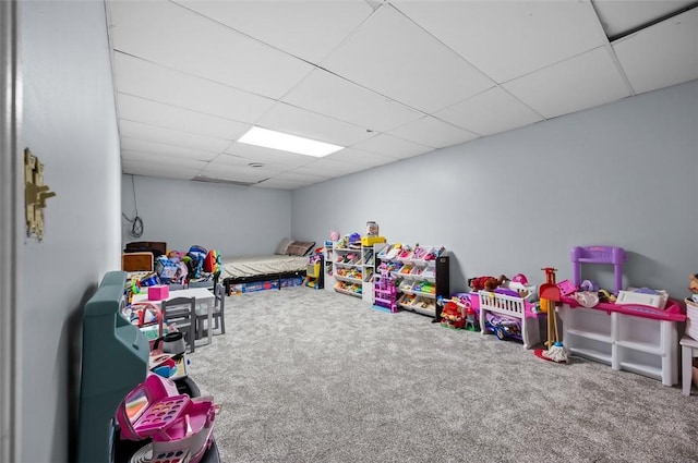 playroom with carpet floors and a paneled ceiling