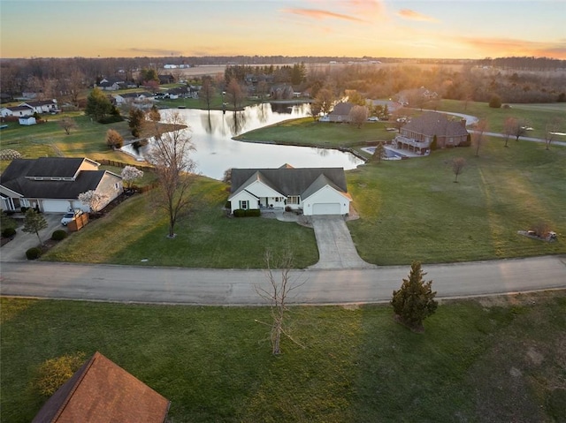 aerial view at dusk featuring a water view