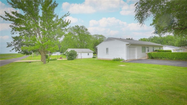 1302 Clement Ave, Forsyth, IL 62535 - view of green lawn featuring asphalt driveway and an outdoor structure