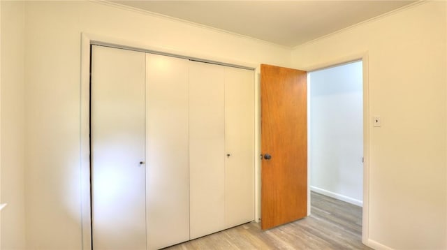 1302 Clement Ave, Forsyth, IL 62535 - unfurnished bedroom featuring crown molding, light wood finished floors, a closet, and baseboards