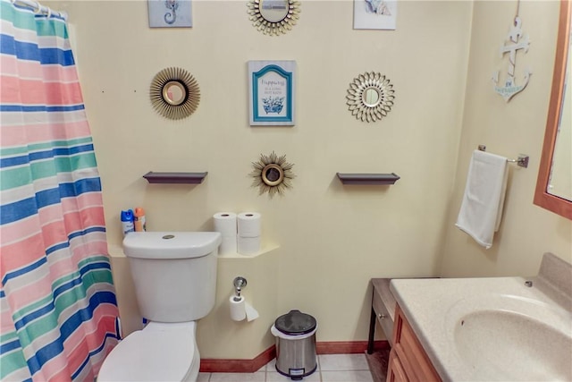 bathroom with toilet, baseboards, tile patterned flooring, and vanity