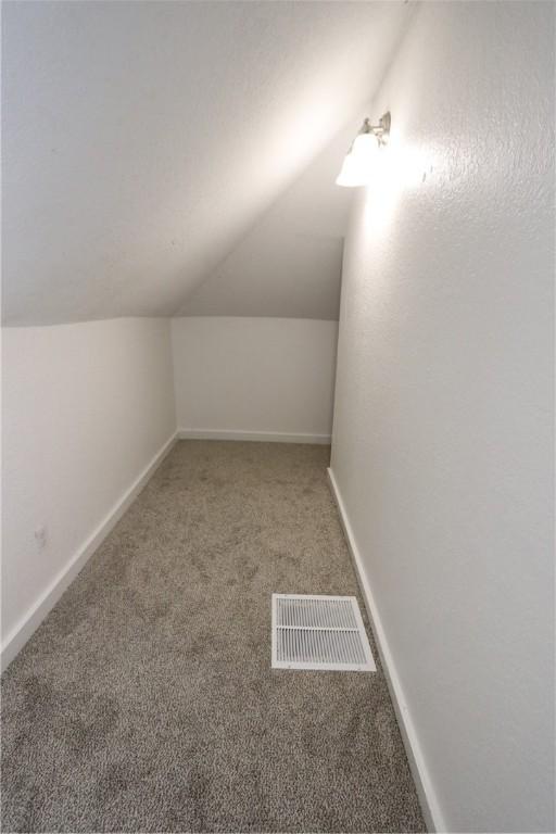 bonus room featuring visible vents, baseboards, carpet, and vaulted ceiling