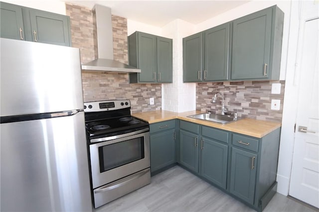 kitchen with a sink, wall chimney range hood, tasteful backsplash, and stainless steel appliances