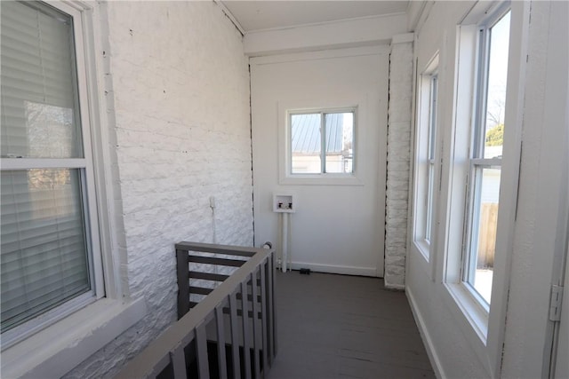 hall featuring baseboards, an upstairs landing, and wood finished floors