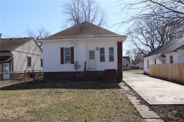 exterior space with fence, roof with shingles, a front yard, and entry steps