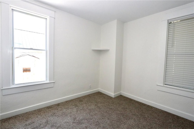 carpeted empty room with baseboards