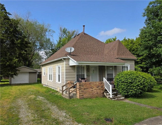 403 11th St, Georgetown, IL 61846 - view of front of home with a porch, a shingled roof, a front lawn, an outdoor structure, and a detached garage