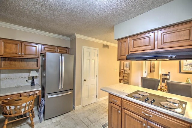 5307 Yavapai Dr, Forsyth, IL 62535 - kitchen featuring freestanding refrigerator, black electric stovetop, light countertops, brown cabinets, and ornamental molding