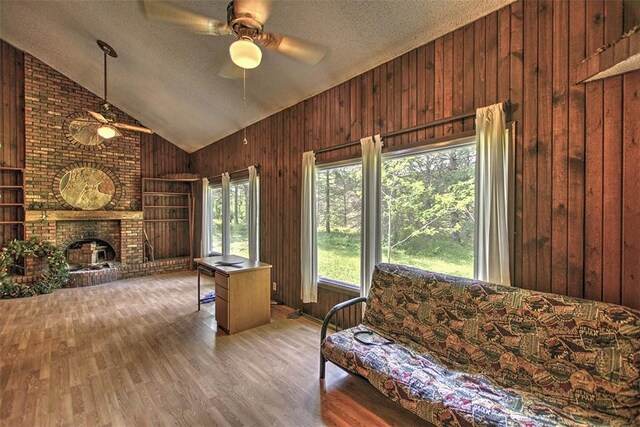 2752 N Sangamon Rd, Decatur, IL 62521 - living area with ceiling fan, wooden walls, lofted ceiling, wood finished floors, and a textured ceiling