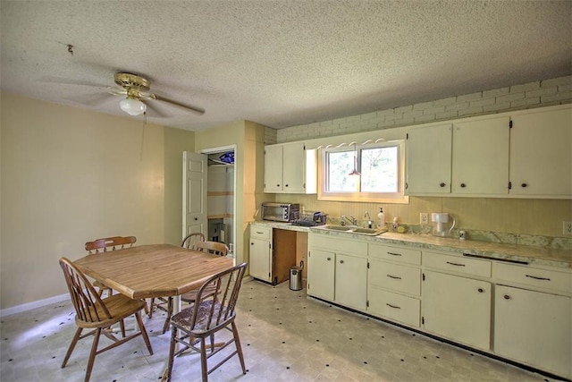 2752 N Sangamon Rd, Decatur, IL 62521 - kitchen featuring a textured ceiling, a sink, a ceiling fan, light flooring, and light countertops