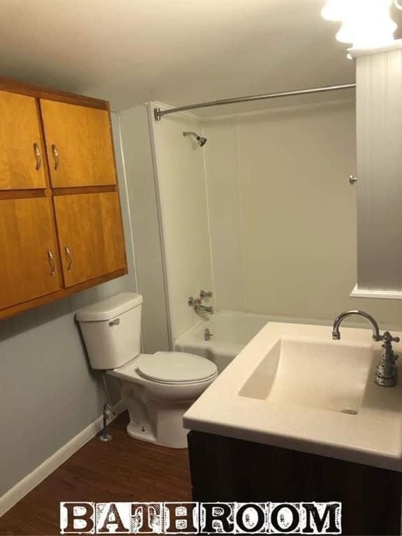 full bathroom with toilet, sink, hardwood / wood-style floors, and tub / shower combination