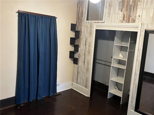 interior space featuring dark hardwood / wood-style flooring and wood walls