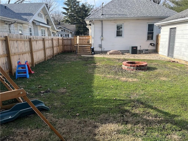 view of yard with central AC unit and an outdoor fire pit