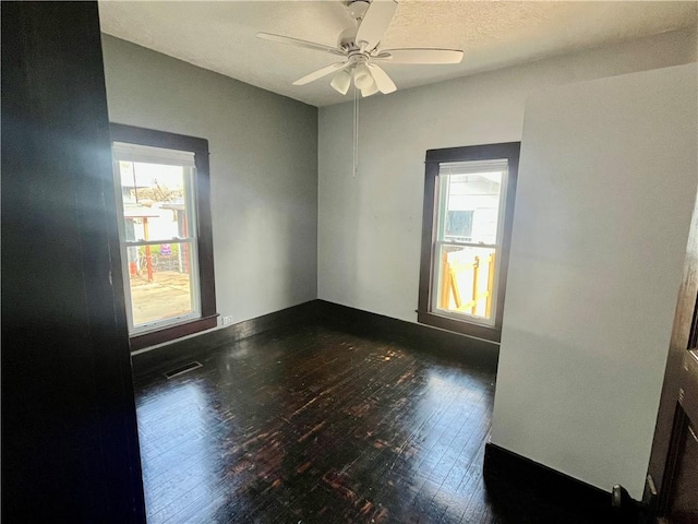 empty room with dark hardwood / wood-style floors and ceiling fan