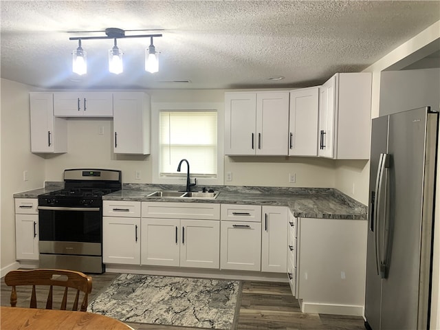 kitchen with stainless steel appliances, sink, hanging light fixtures, and white cabinets