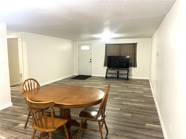 dining room featuring dark hardwood / wood-style flooring and a textured ceiling