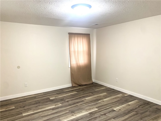 unfurnished room featuring dark hardwood / wood-style flooring and a textured ceiling