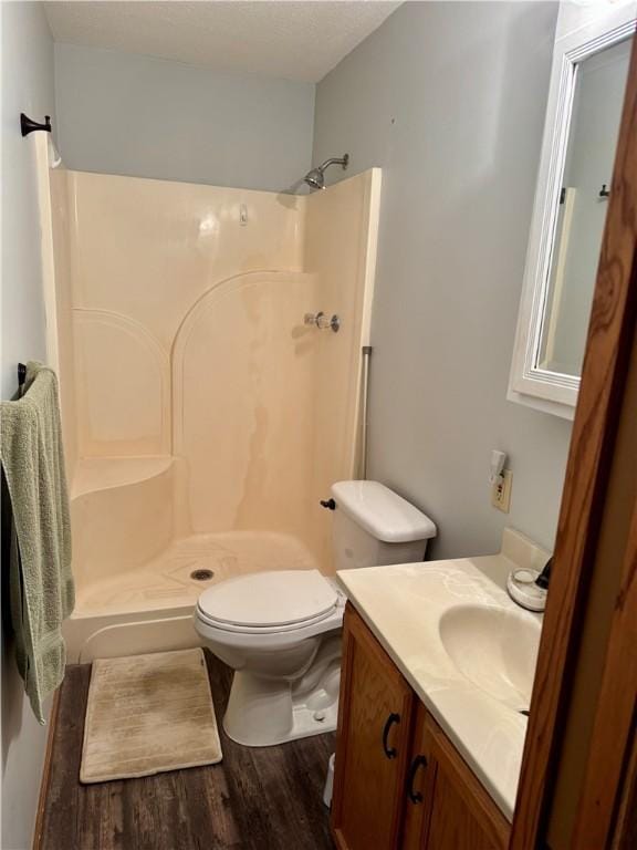 full bath with vanity, toilet, a shower, and wood finished floors