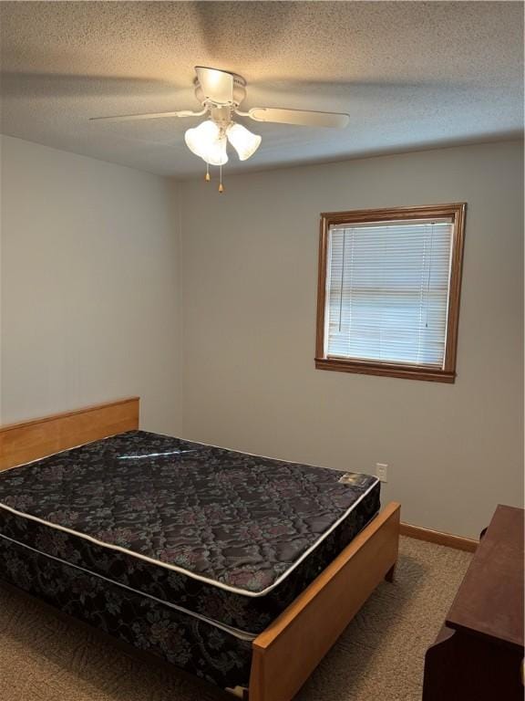 bedroom with baseboards, carpet floors, a textured ceiling, and ceiling fan