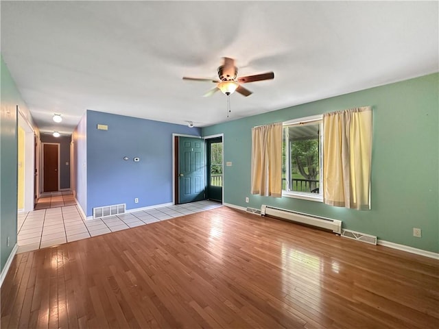 2145 E 1500 N Rd, Shelbyville, IL 62565 - unfurnished living room featuring baseboard heating, wood-type flooring, a ceiling fan, and baseboards