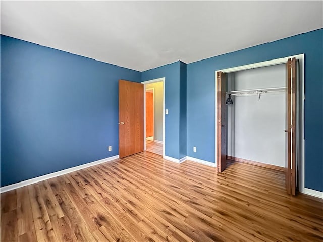 2145 E 1500 N Rd, Shelbyville, IL 62565 - unfurnished bedroom featuring wood finished floors, baseboards, and a closet