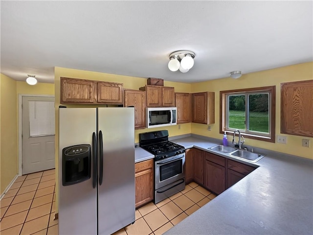 2145 E 1500 N Rd, Shelbyville, IL 62565 - kitchen featuring stainless steel appliances, a sink, brown cabinetry, light tile patterned flooring, and light countertops
