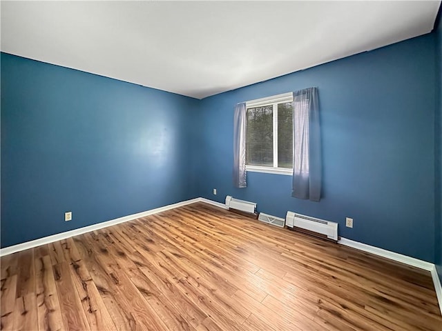 2145 E 1500 N Rd, Shelbyville, IL 62565 - unfurnished room featuring baseboard heating, a baseboard heating unit, wood finished floors, and baseboards