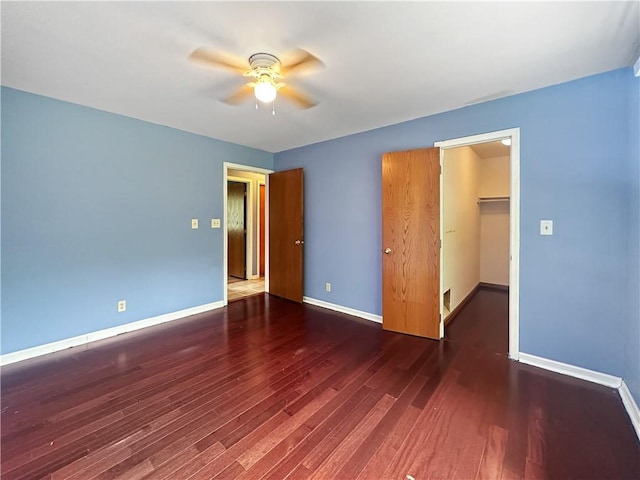 2145 E 1500 N Rd, Shelbyville, IL 62565 - unfurnished bedroom with wood finished floors, a spacious closet, baseboards, a ceiling fan, and a closet