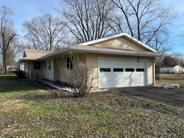 view of property exterior featuring a garage and a lawn