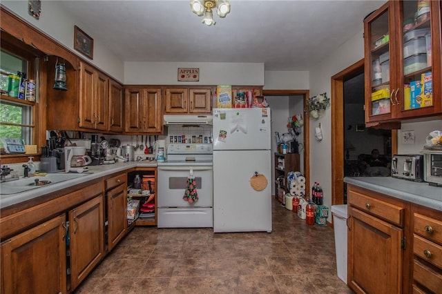 1104 N 30th St, Mattoon, IL 61938 - kitchen featuring white appliances, under cabinet range hood, brown cabinets, and light countertops