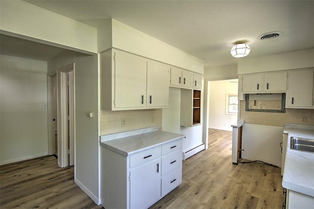 2631 Gregory Ct, Decatur, IL 62526 - kitchen with a baseboard radiator, decorative backsplash, light wood-style floors, and light countertops