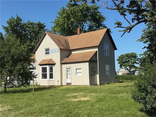5296 E County Road 1100n, Mattoon, IL 61938 - rear view of house with roof with shingles, a chimney, and a lawn