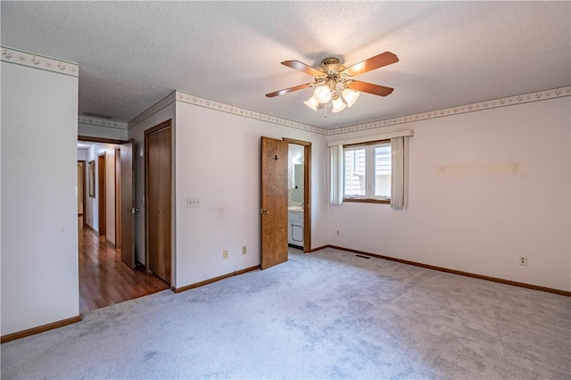 4642 Dogwood Ct, Decatur, IL 62526 - unfurnished bedroom featuring carpet flooring, a textured ceiling, ceiling fan, and connected bathroom