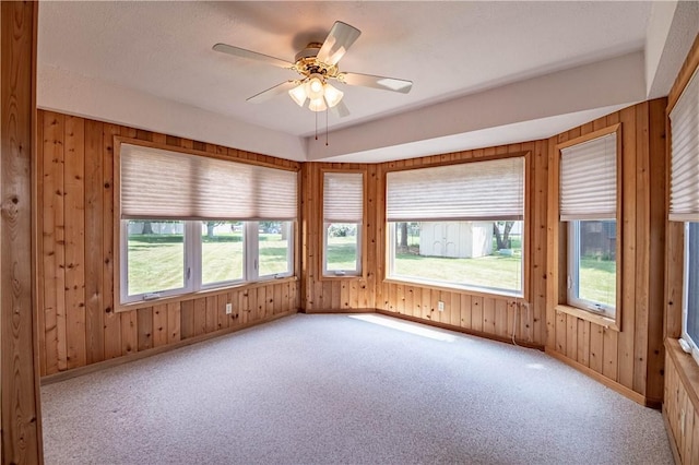 4642 Dogwood Ct, Decatur, IL 62526 - empty room featuring healthy amount of natural light, carpet, wooden walls, and a ceiling fan