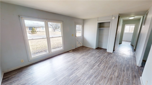 unfurnished bedroom featuring a closet, baseboards, and wood finished floors