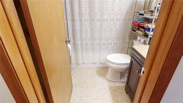 bathroom with toilet, vanity, and wallpapered walls