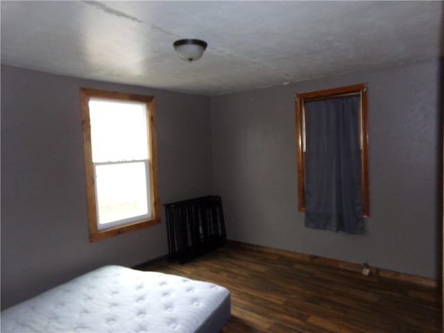 bedroom with dark wood-type flooring