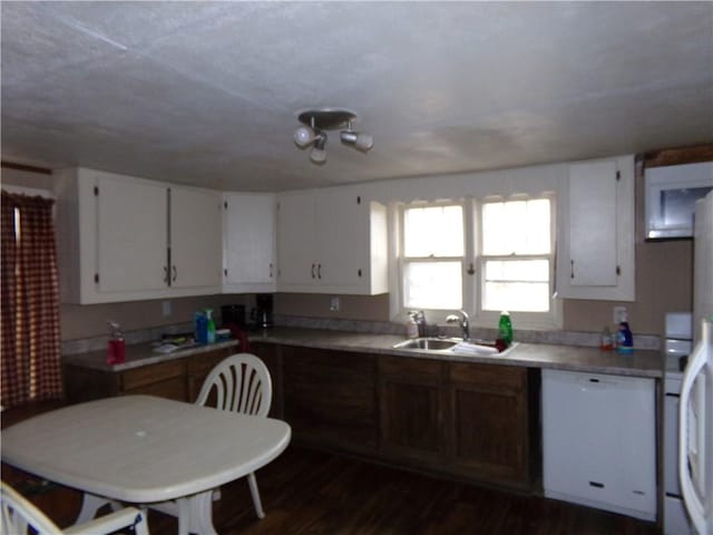 kitchen featuring dishwasher, sink, dark wood-type flooring, and white cabinets