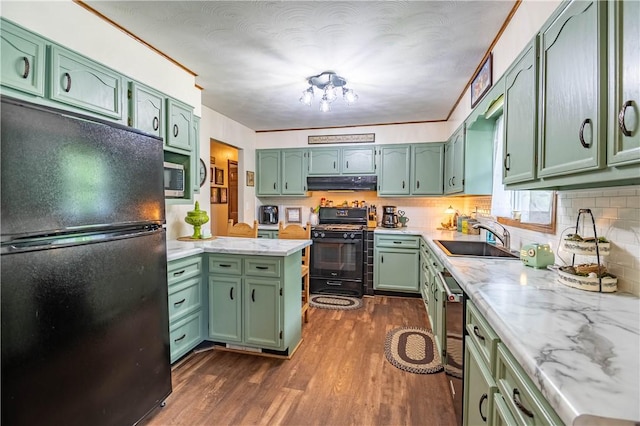 37 Ohio Dr, Decatur, IL 62526 - kitchen with black appliances, green cabinets, under cabinet range hood, dark wood finished floors, and decorative backsplash