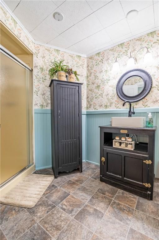 37 Ohio Dr, Decatur, IL 62526 - bathroom with wainscoting, a stall shower, wallpapered walls, vanity, and stone finish floors